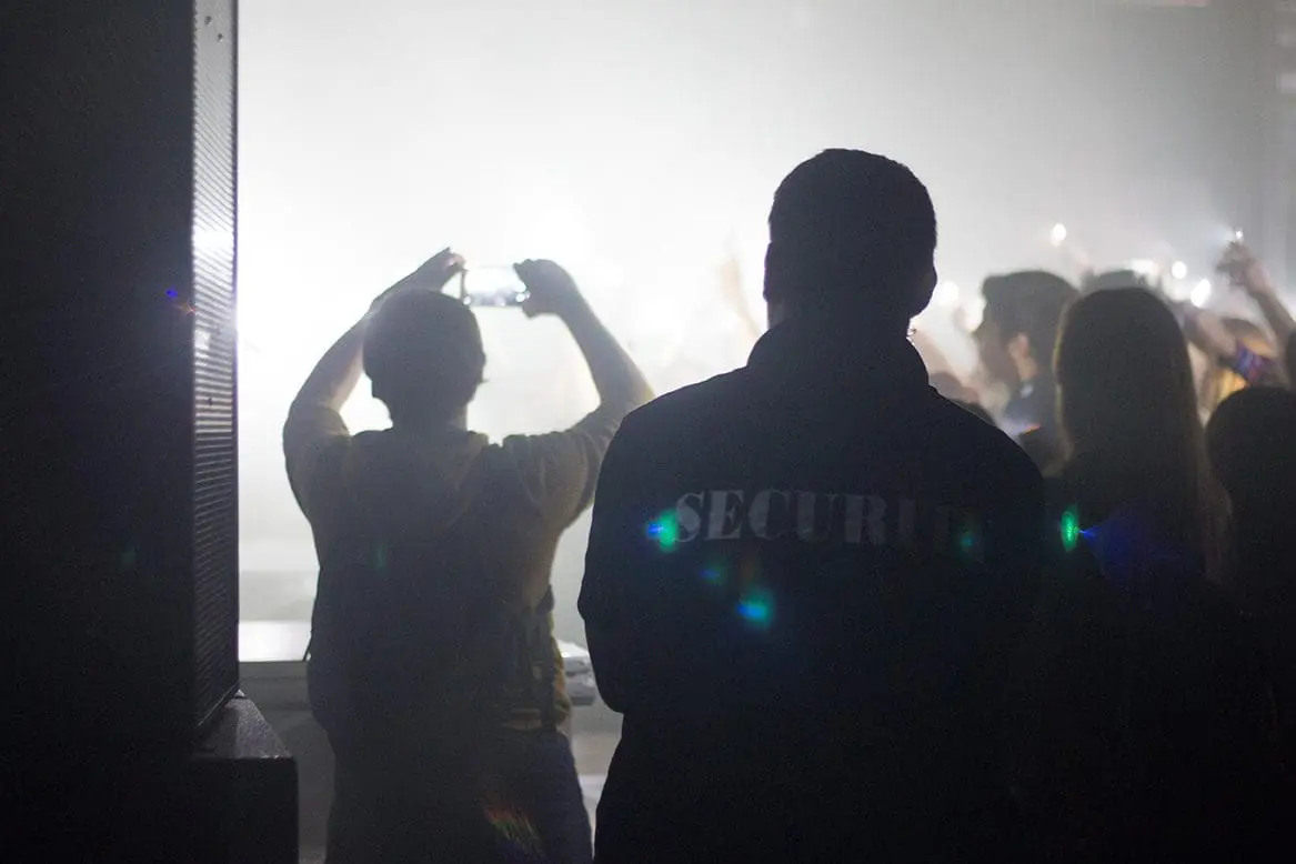 Security officer watching a festival crowd from the stage side