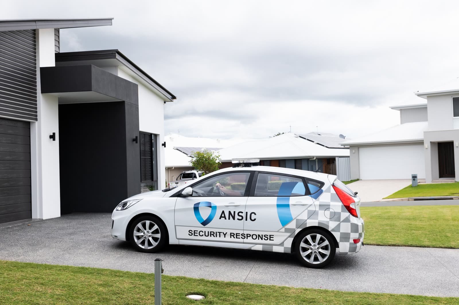 ANSIC Security Response patrol car parked on a new-estate street in front of newly built homes