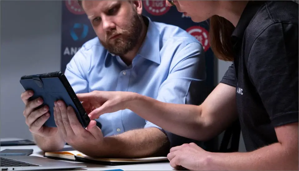 ANSIC officer and colleague reviewing a tablet during a professional consultation