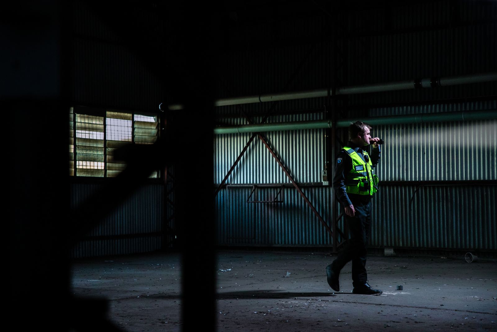 Night patrol with a flashlight inside an industrial building