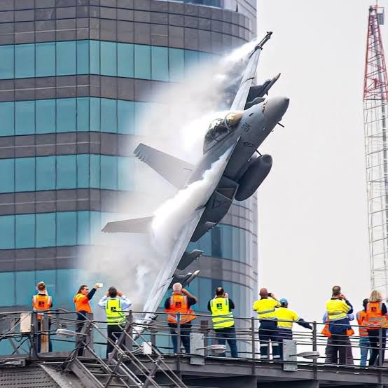 Fighter jet climbing past a Brisbane high-rise during Riverfire, watched from a rooftop