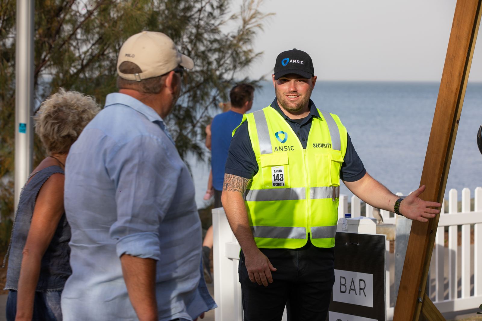 ANSIC event security officer assisting patrons at an outdoor venue